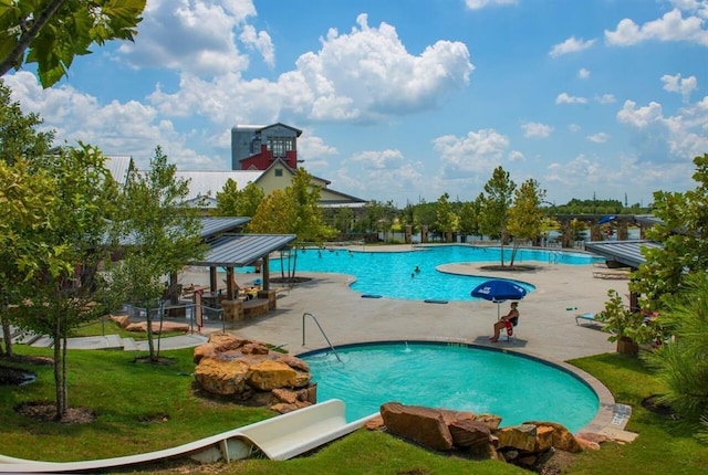 view of swimming pool featuring a yard and a patio area