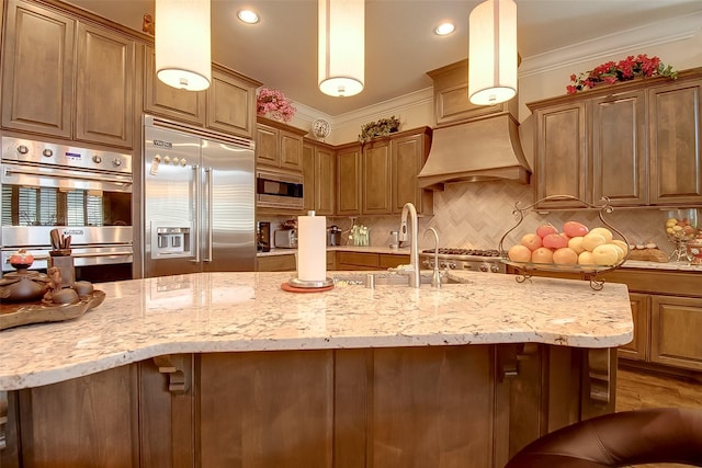 kitchen with tasteful backsplash, a breakfast bar, built in appliances, light stone countertops, and crown molding