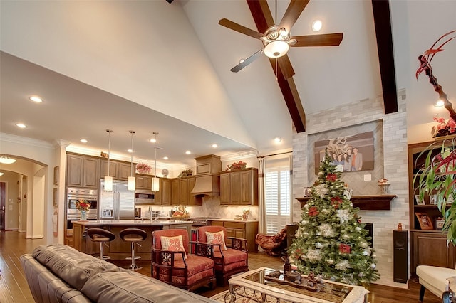 living room with arched walkways, ceiling fan, ornamental molding, wood finished floors, and high vaulted ceiling