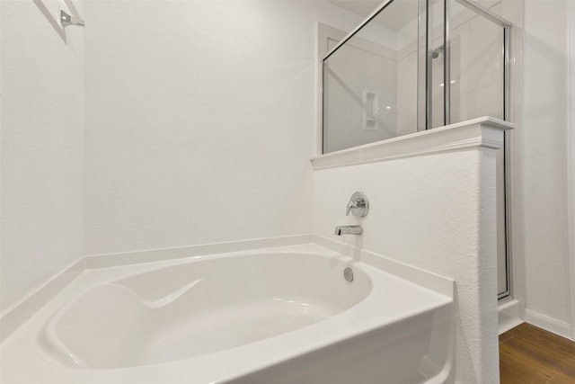 bathroom featuring wood-type flooring and plus walk in shower