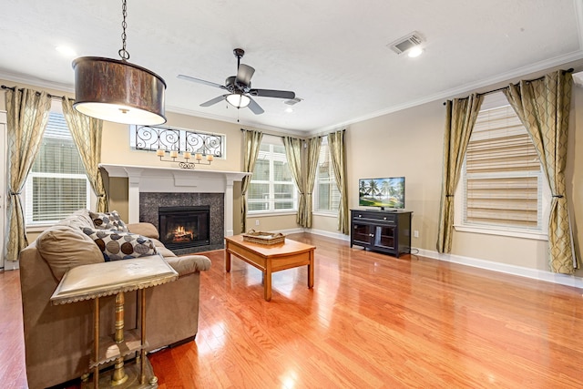 living room featuring ornamental molding, wood-type flooring, and ceiling fan