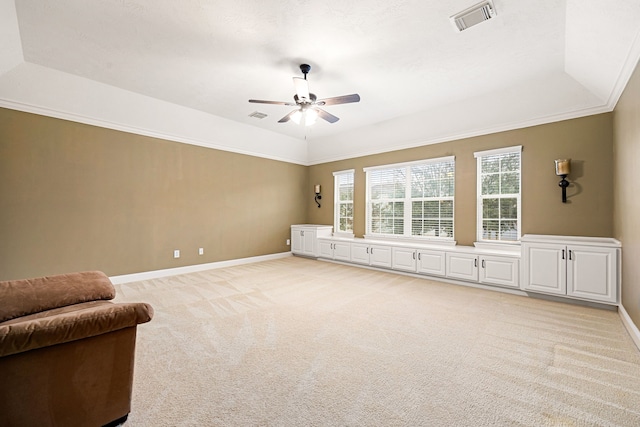 unfurnished room with crown molding, ceiling fan, a tray ceiling, and light carpet