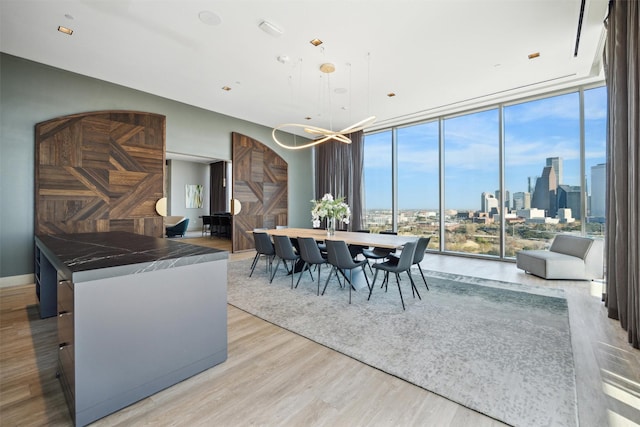 dining area featuring expansive windows, a barn door, and light hardwood / wood-style floors