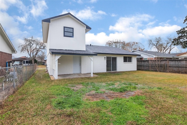 rear view of property with a lawn and a patio