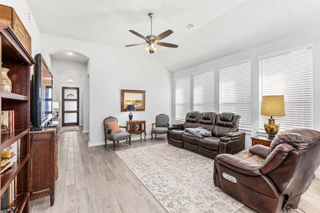 living room with ceiling fan, vaulted ceiling, and light wood-type flooring