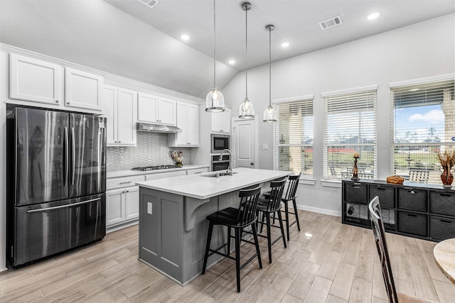 kitchen featuring white cabinetry, appliances with stainless steel finishes, sink, and a center island with sink