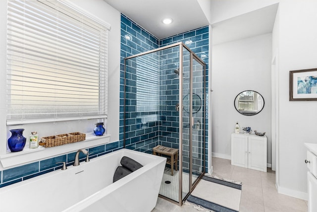 bathroom with tile patterned flooring, vanity, and separate shower and tub