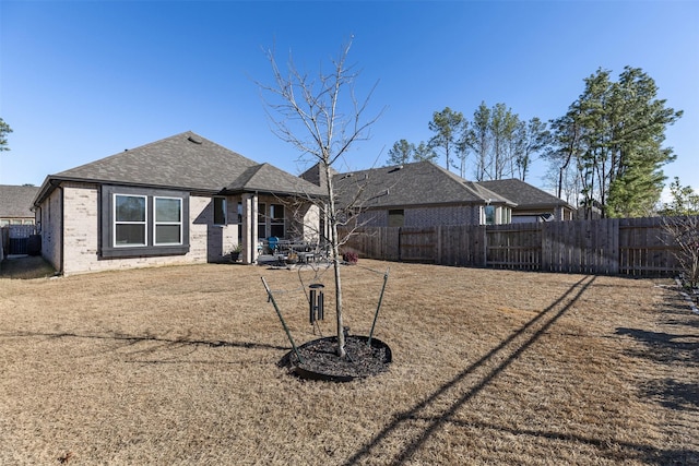 rear view of property with a yard