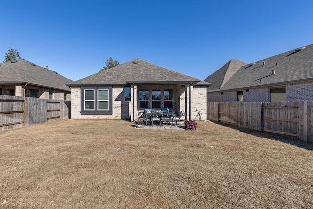 back of property featuring a lawn and a patio