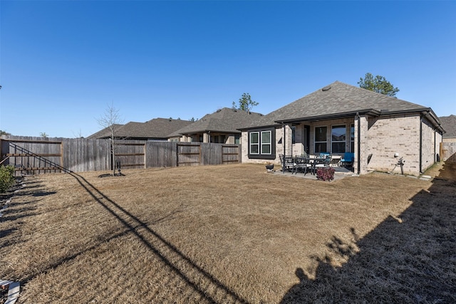 rear view of property with a yard and a patio area