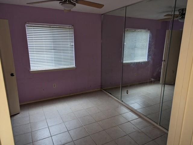 tiled empty room with ceiling fan