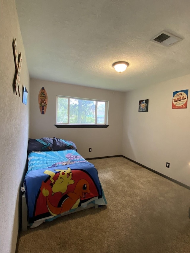 bedroom featuring a textured ceiling and carpet