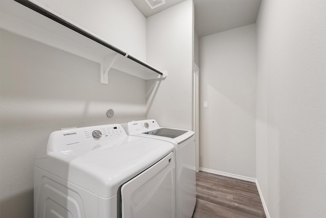 clothes washing area with washer and dryer and dark hardwood / wood-style floors