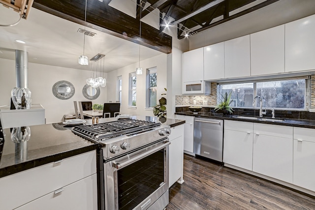 kitchen featuring sink, white cabinets, dark hardwood / wood-style flooring, hanging light fixtures, and stainless steel appliances