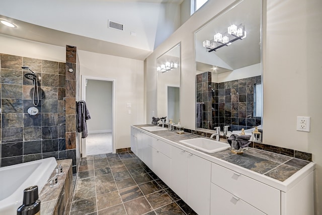 bathroom with lofted ceiling, vanity, and shower with separate bathtub