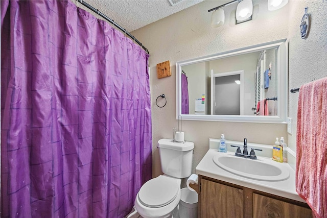 bathroom with vanity, a textured ceiling, and toilet