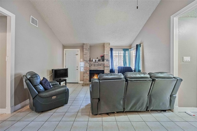 living room featuring vaulted ceiling, light tile patterned floors, a textured ceiling, and a fireplace