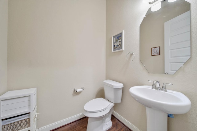 bathroom featuring wood-type flooring and toilet