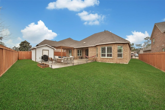 back of house featuring a shed, a patio area, and a lawn