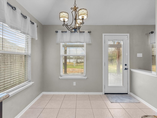 doorway with an inviting chandelier, vaulted ceiling, and light tile patterned flooring