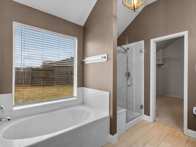 bathroom with lofted ceiling and plus walk in shower