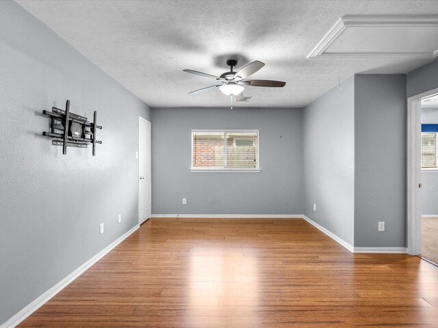 spare room with ceiling fan, wood-type flooring, and a textured ceiling