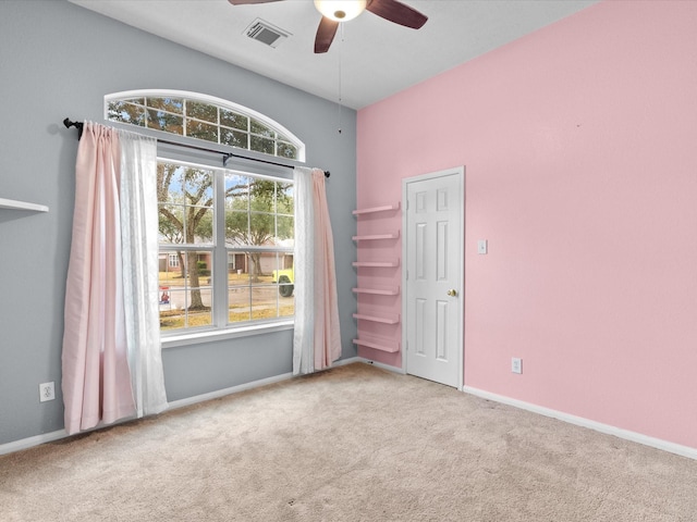 carpeted spare room featuring ceiling fan