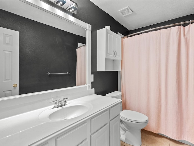 bathroom with tile patterned flooring, vanity, and toilet