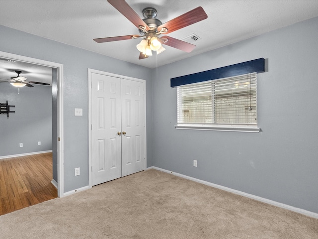 unfurnished bedroom with light colored carpet and ceiling fan