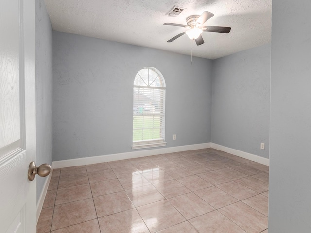 tiled empty room featuring a textured ceiling and ceiling fan