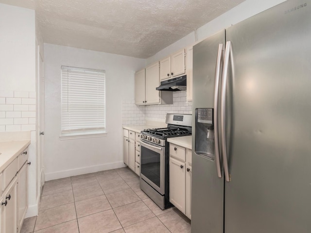 kitchen featuring decorative backsplash, stainless steel appliances, a textured ceiling, and light tile patterned flooring