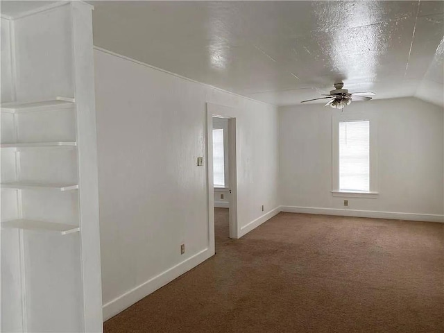 carpeted spare room featuring a ceiling fan and baseboards