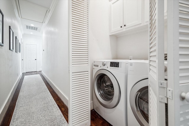 washroom with dark hardwood / wood-style flooring, cabinets, crown molding, and washer and dryer