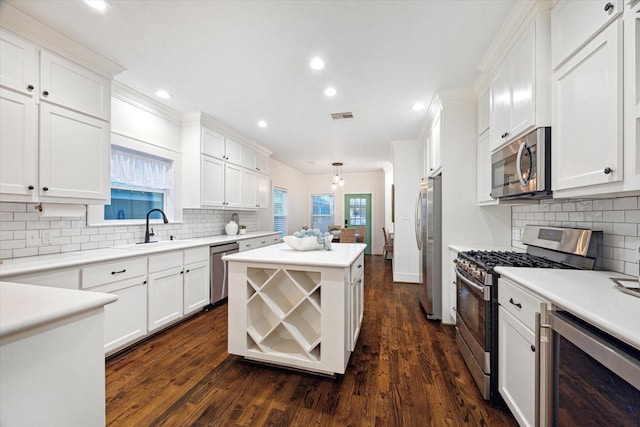 kitchen featuring stainless steel appliances, white cabinetry, sink, and ornamental molding