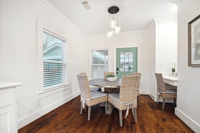 dining room featuring crown molding, dark hardwood / wood-style floors, and a healthy amount of sunlight