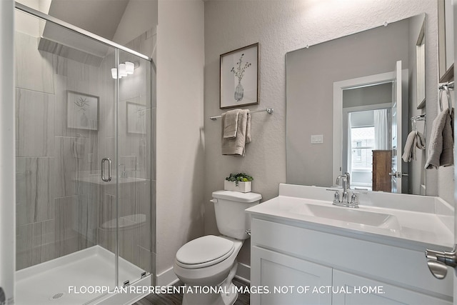 full bath with toilet, a textured wall, a shower stall, and vanity