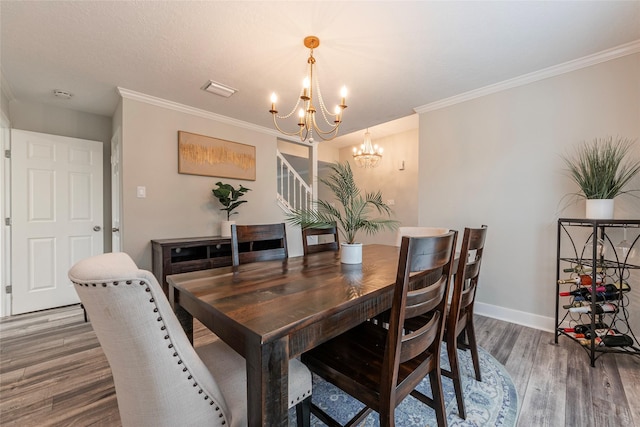 dining area featuring a notable chandelier, crown molding, and wood-type flooring