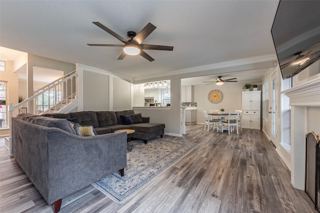 living room with hardwood / wood-style flooring, ceiling fan, crown molding, and a textured ceiling