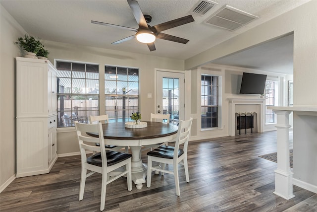 dining room featuring ceiling fan, plenty of natural light, dark hardwood / wood-style floors, and a textured ceiling