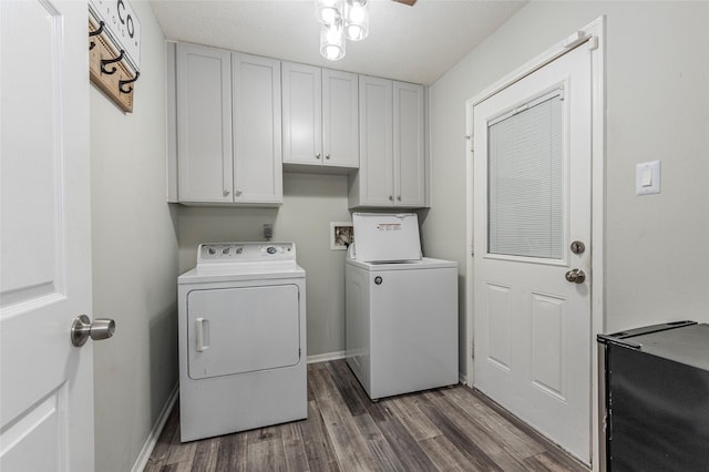 clothes washing area with independent washer and dryer, cabinets, dark wood-type flooring, and a textured ceiling