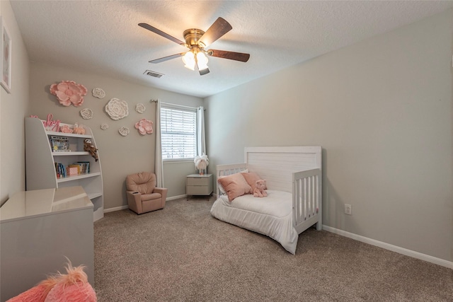 carpeted bedroom with ceiling fan and a textured ceiling