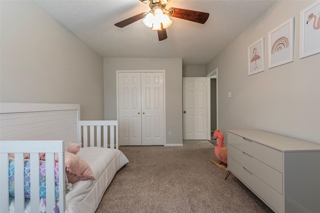 carpeted bedroom featuring ceiling fan, a closet, and a textured ceiling