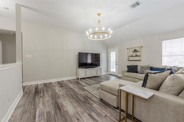 living room featuring lofted ceiling, a notable chandelier, and wood-type flooring