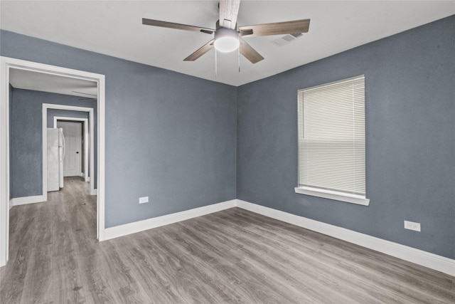 empty room with ceiling fan and light hardwood / wood-style floors