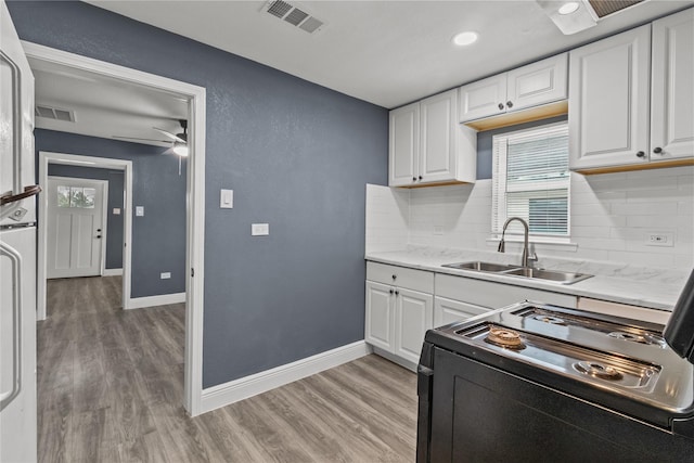 kitchen featuring white cabinetry, black electric range oven, sink, and light wood-type flooring