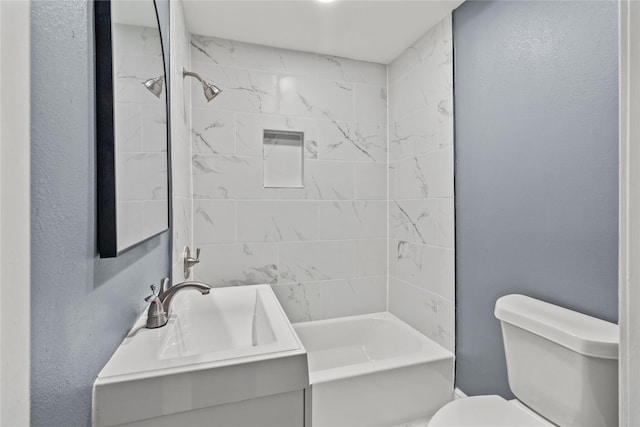 full bathroom featuring tiled shower / bath, vanity, and toilet