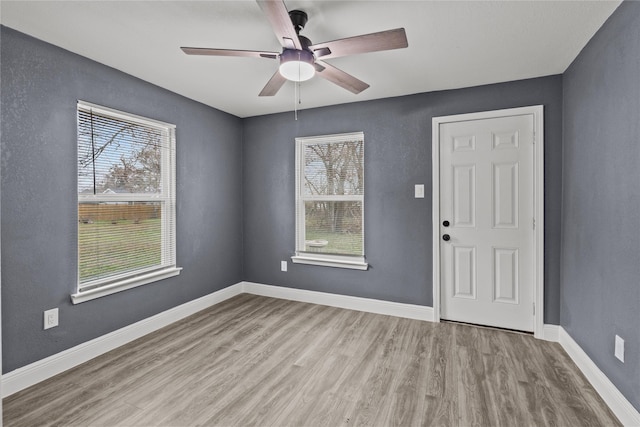 interior space with a wealth of natural light, ceiling fan, and light wood-type flooring