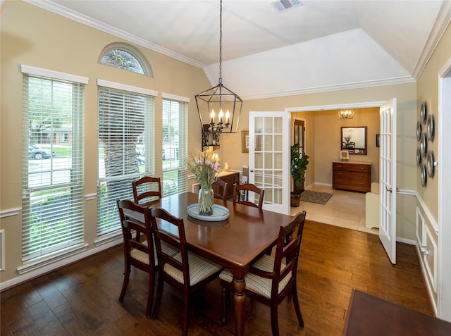 dining room featuring a notable chandelier, dark wood-type flooring, and ornamental molding