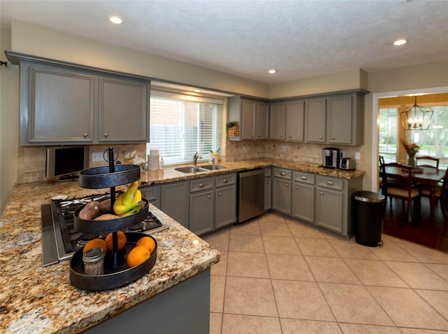 kitchen featuring light tile patterned flooring, sink, gray cabinetry, stainless steel dishwasher, and light stone countertops