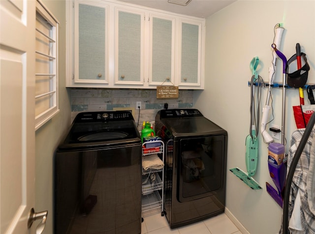 laundry area featuring cabinets, washing machine and dryer, and light tile patterned floors